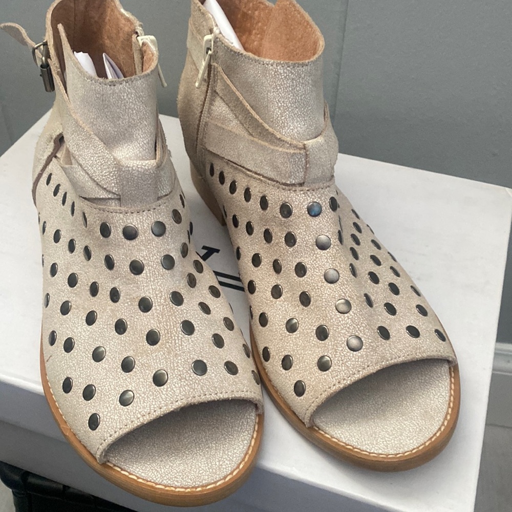 Never wear Very nice sandals with side zipper and belt around with gold snaps .